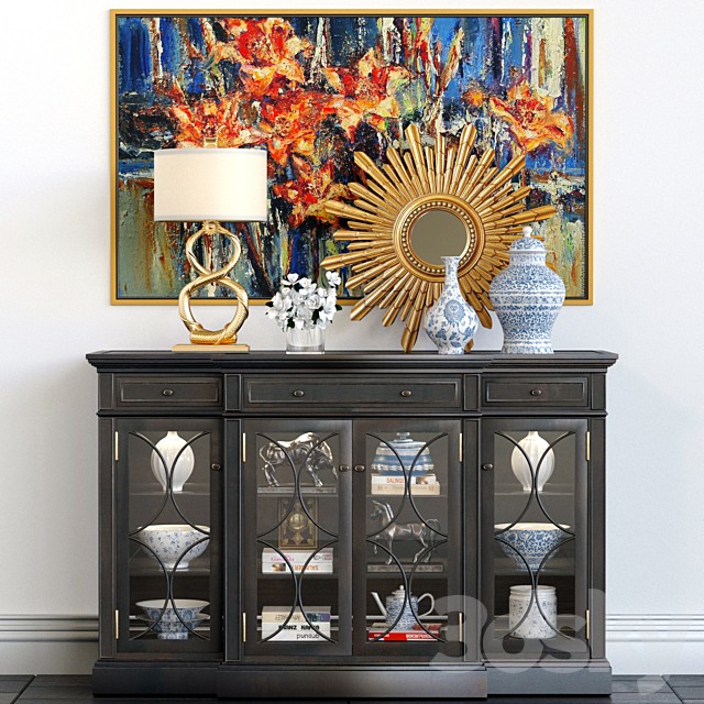 A chest of drawers with a collection of decor, a lamp and a set of sculptures
